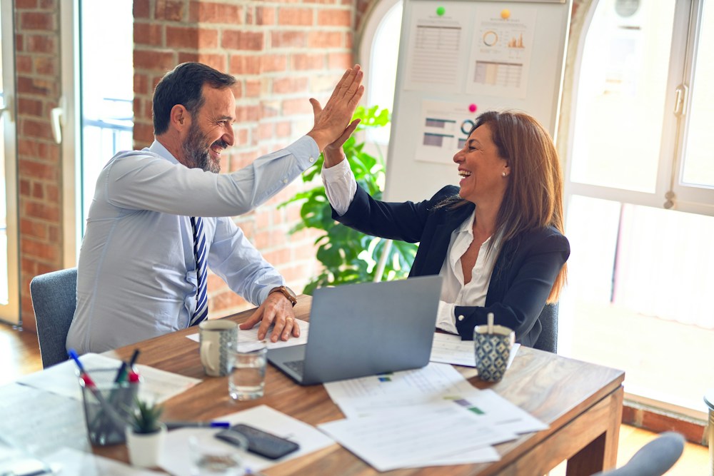 Business consultants collaborating around a laptop